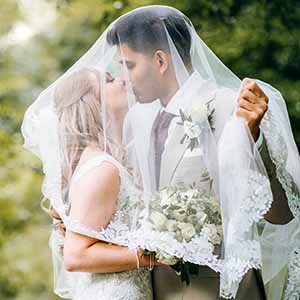 brud og gom kysser foran bryllupsfotografen i skoven ved Marselisborg Aarhus